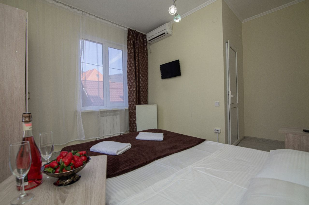 Гостевой дом Солнышко в Геленджике,двуспальная кровать и вид из окна номера.jpg