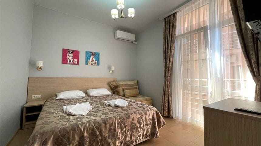 Гостевой дом Тельмана 23 в Геленджике- двуспальная кровать и картинка с собачками в номере.jpg