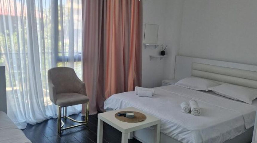 Отель New House Kobuleti кровать с видом на окно.jpg