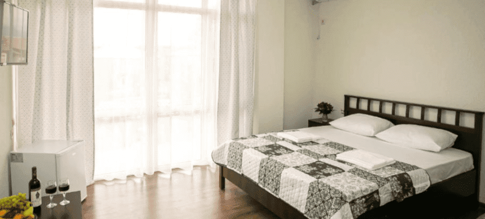 Двуспальная кровать и бутылка вина на столике в отеле СанЗазила, Абхазия.png Двуспальная кровать и бутылка вина на столике в отеле СанЗазила, Абхазия.png