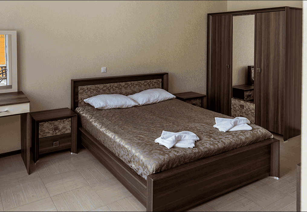 Гостевой дом Сказка в Гагра, номер с коричневой двуспальной кроватью.png