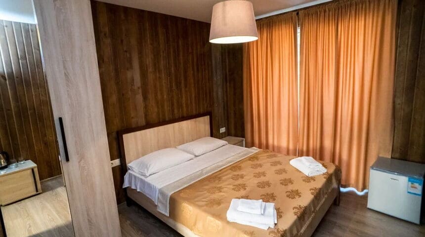 Отель Водопад в Новом Афоне, вид на кровать с завешенными шторами окно.jpg